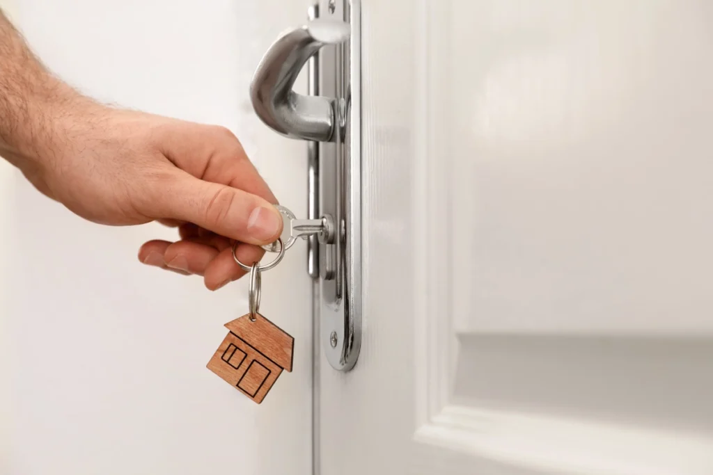 man with key opening front door closeup space text